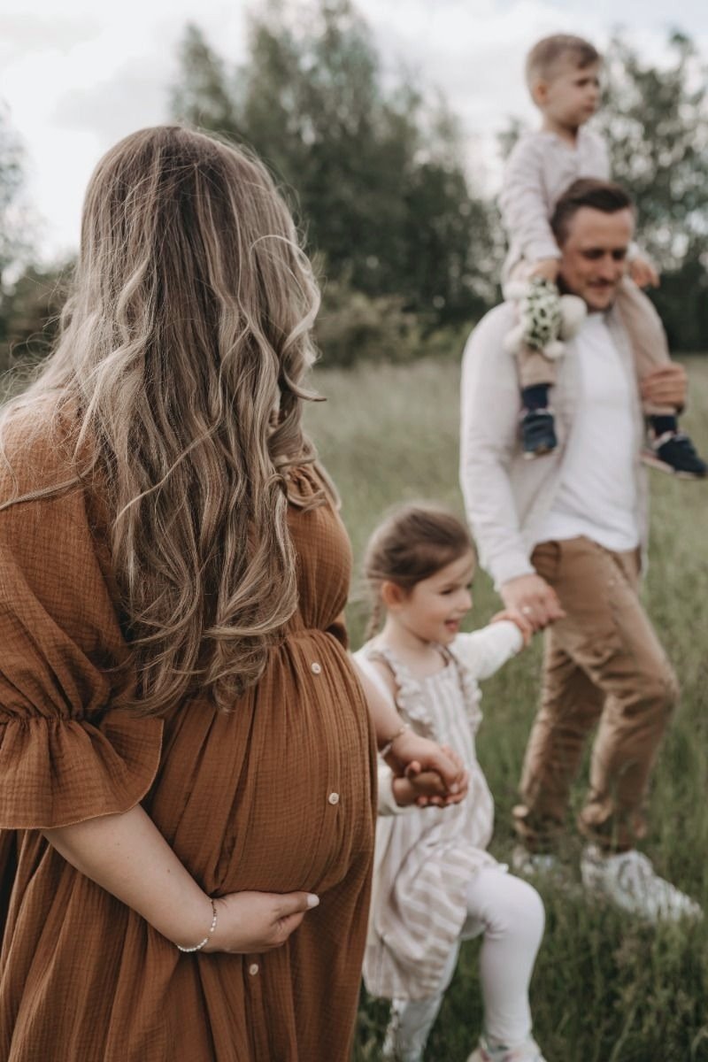 Femme enceinte en famille, promenade dans un champ